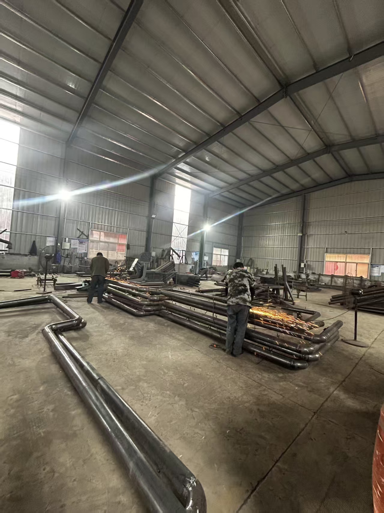 Workers processing metal frames inside our workshop