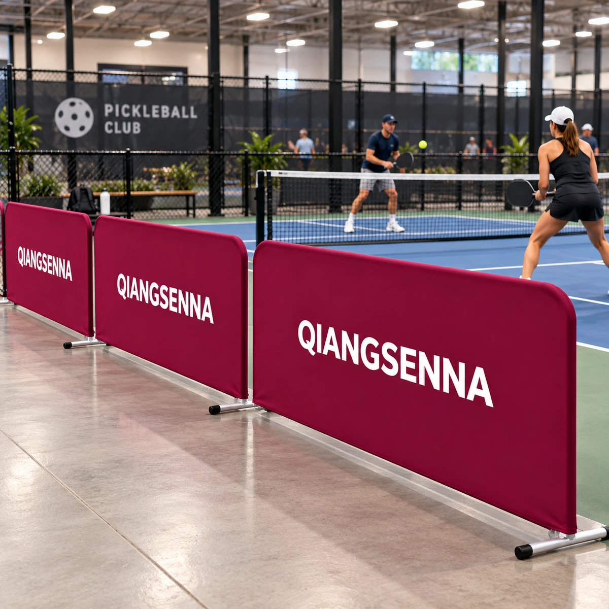 Burgundy modular court barriers around an indoor pickleball court