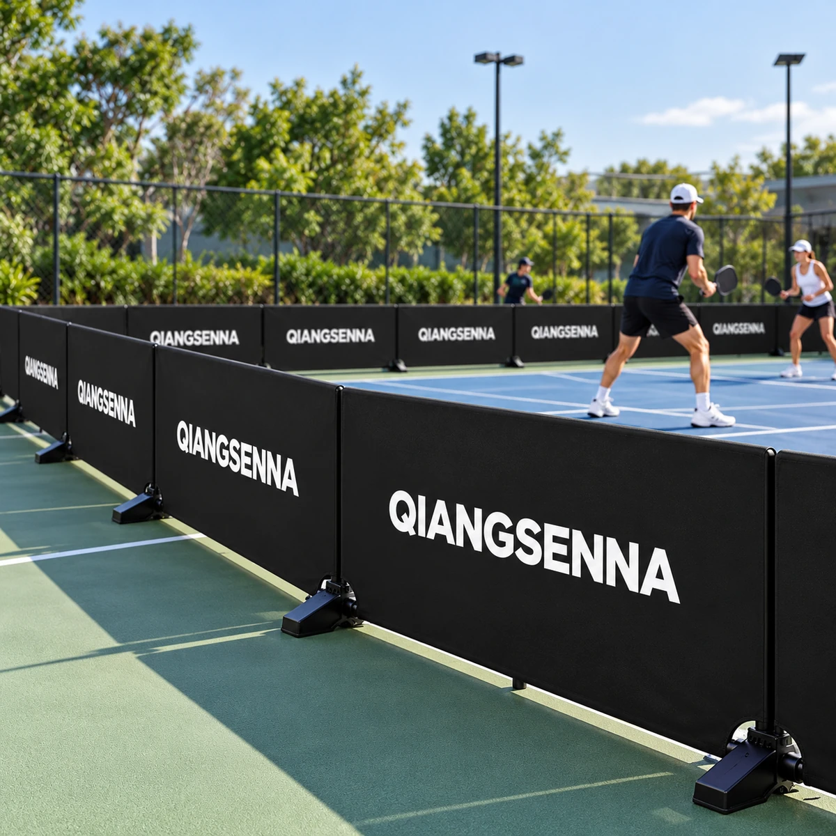 Black QIANGSENNA PVC barriers beside outdoor pickleball players