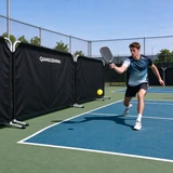 Black Qiangsenna barriers beside a player on an outdoor pickleball court